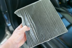 hand hold dirty car air conditioning filter by CAB Detailing NJ Professionals
